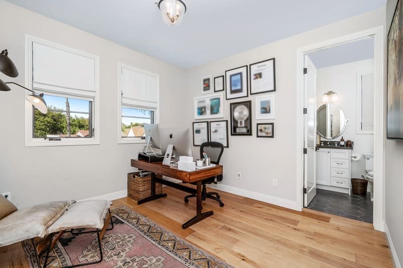 Oficina en casa moderna con escritorio de madera, computadora de escritorio, silla ergonómica y acceso directo a baño privado - Casa Velaris