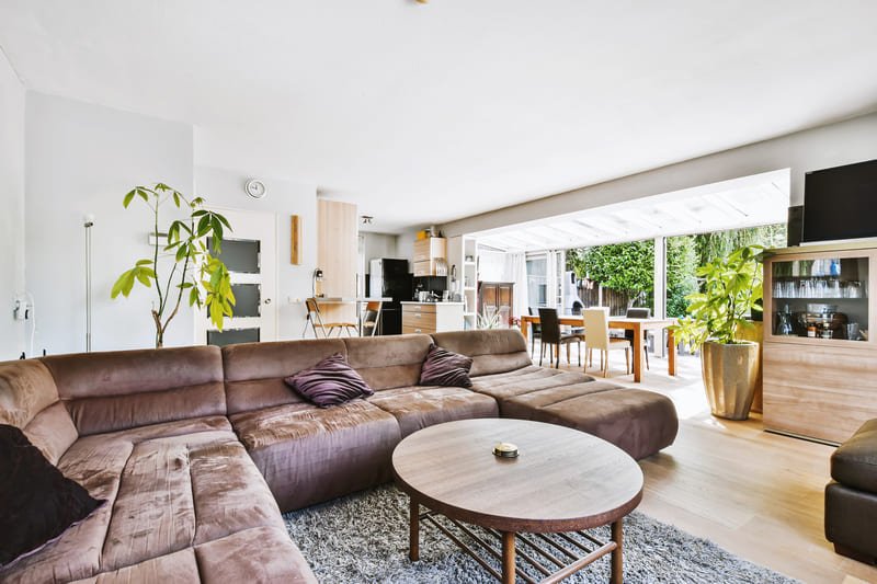 Sala de estar moderna de concepto abierto con chimenea minimalista, suelos de madera clara y vista hacia la cocina y comedor - Casa Velaris